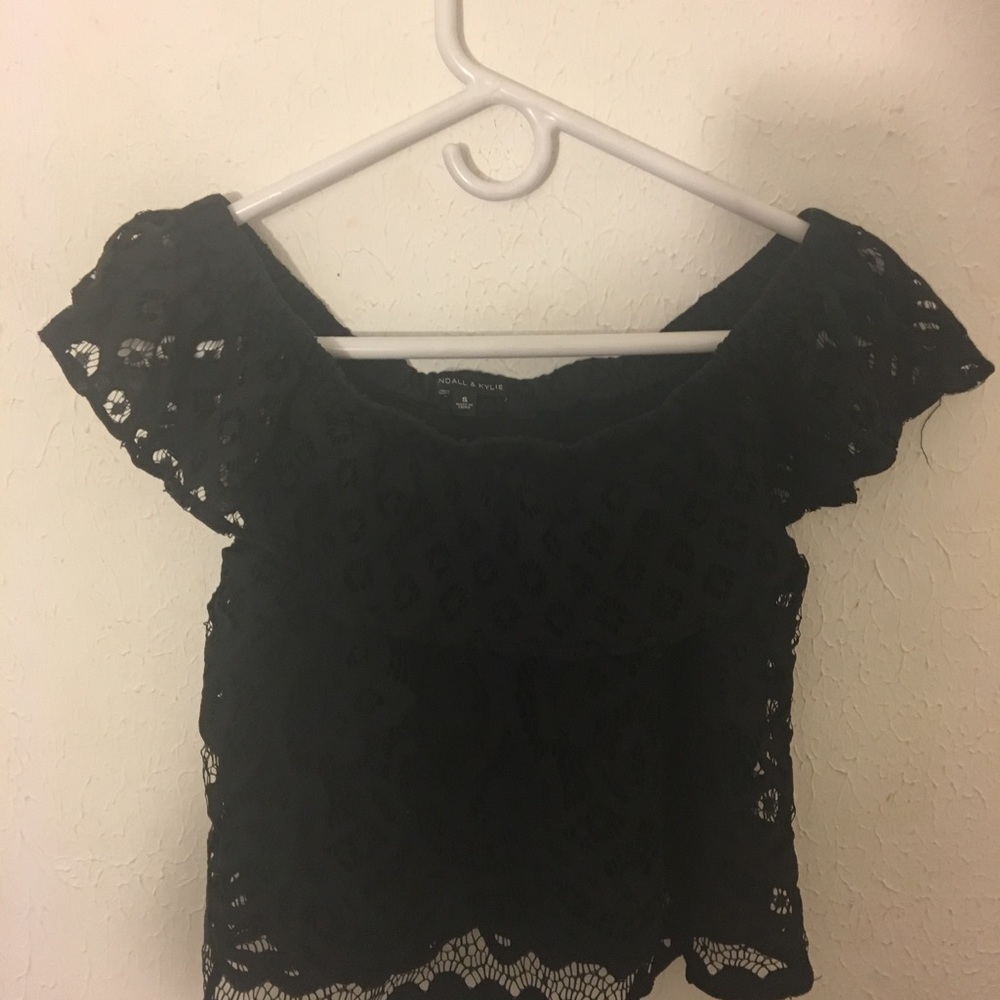 An off the shoulder black lace crop top